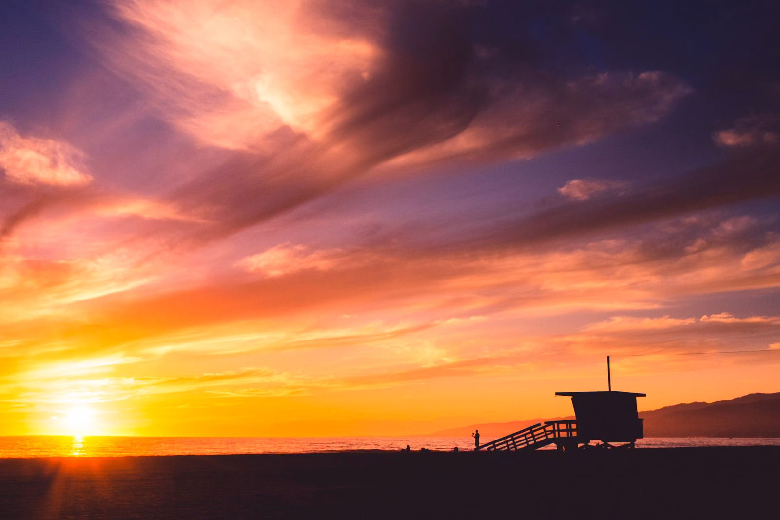 A lifeguard tower silhouetted at sunset on Santa Monica Bay