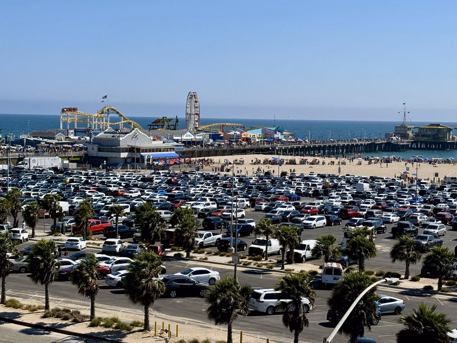 A beach parking lot beside the Santa Monica Pier and Pacific Park